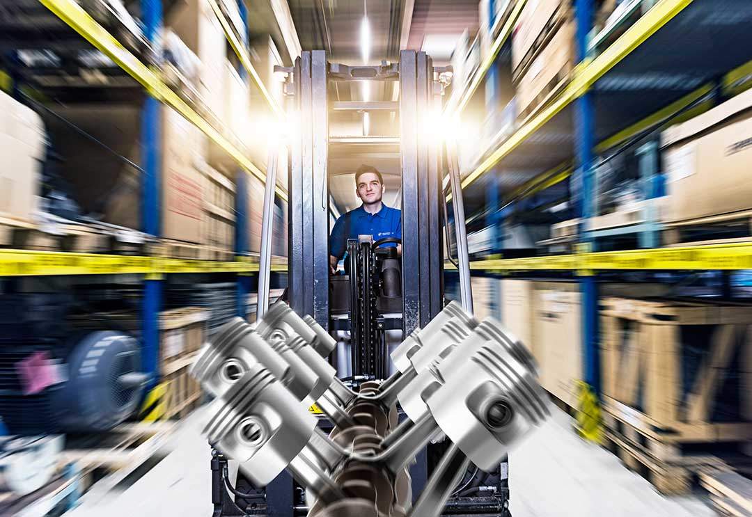 Fachkraft für Lagerlogistik fährt mit Gabelstapler durch ein Lager Fachkraft für Lagerlogistik fährt mit Gabelstapler durch ein Lager