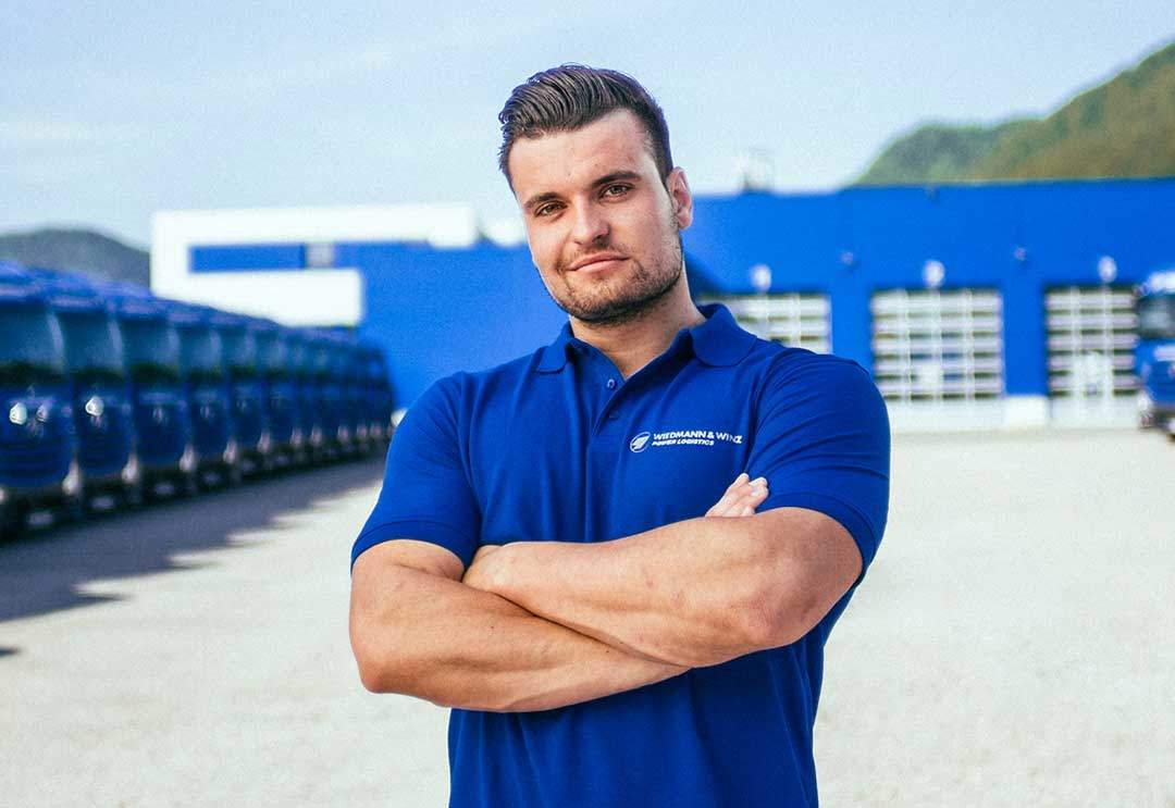 Berufskraftfahrer steh vor Garage mit vielen LKWs Berufskraftfahrer steh vor Garage mit vielen LKWs