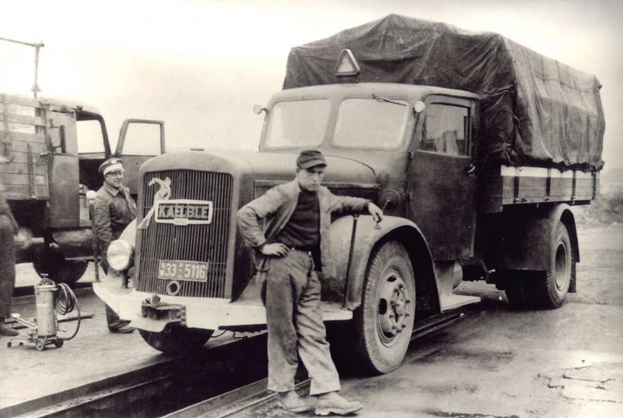 Ein Mann steht vor einem alten Holzvergaser-LKW.